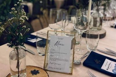 Deux lits simples avec couvre-lits bleus, une lampe de chevet, un bureau et un lavabo dans une chambre lumineuse.