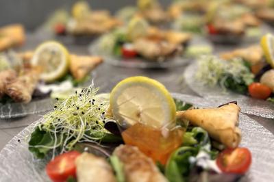 Assiettes garnies de samoussas, salade, tomates cerises, germes de luzerne et rondelles de citron.