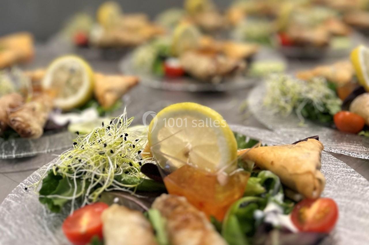 Assiettes garnies de samoussas, salade, tomates cerises, germes de luzerne et rondelles de citron.