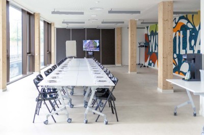 Façade d'un immeuble moderne en bois et verre avec des fenêtres alignées, situé dans un environnement urbain.