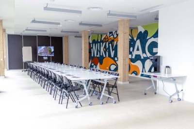 Façade d'un immeuble moderne en bois et verre avec des fenêtres alignées, situé dans un environnement urbain.