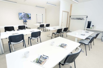 Façade d'un immeuble moderne en bois et verre avec des fenêtres alignées, situé dans un environnement urbain.