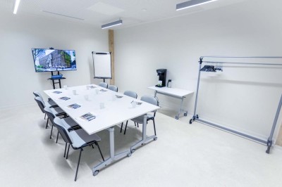 Façade d'un immeuble moderne en bois et verre avec des fenêtres alignées, situé dans un environnement urbain.