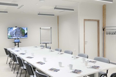 Façade d'un immeuble moderne en bois et verre avec des fenêtres alignées, situé dans un environnement urbain.
