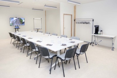 Façade d'un immeuble moderne en bois et verre avec des fenêtres alignées, situé dans un environnement urbain.