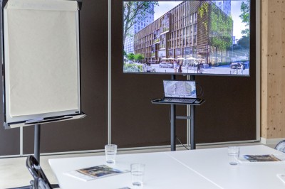 Façade d'un immeuble moderne en bois et verre avec des fenêtres alignées, situé dans un environnement urbain.