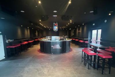 Chemin de gravier bordé de végétation, menant à un bâtiment moderne sous un ciel nuageux.