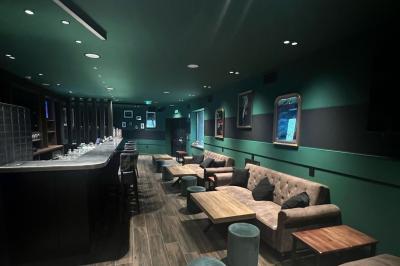 Chemin de gravier bordé de végétation, menant à un bâtiment moderne sous un ciel nuageux.