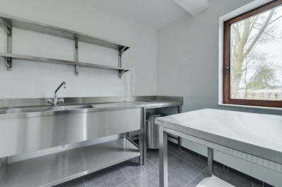 Des personnes discutent debout dans un espace extérieur, entourées de verdure et de mobilier de jardin.