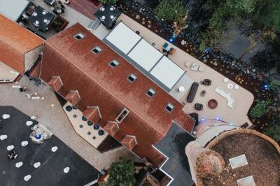 Des personnes discutent debout dans un espace extérieur, entourées de verdure et de mobilier de jardin.