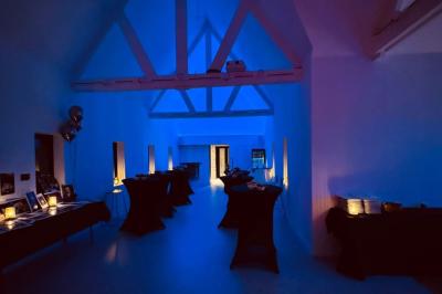 Des personnes discutent debout dans un espace extérieur, entourées de verdure et de mobilier de jardin.