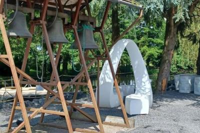 Des personnes discutent debout dans un espace extérieur, entourées de verdure et de mobilier de jardin.