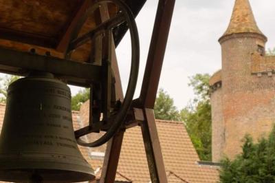 Des personnes discutent debout dans un espace extérieur, entourées de verdure et de mobilier de jardin.