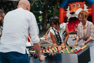 Des personnes discutent debout dans un espace extérieur, entourées de verdure et de mobilier de jardin.