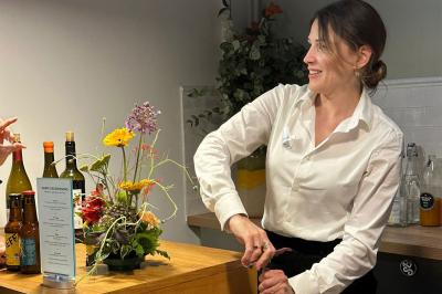 Façade d'un restaurant avec une vitrine éclairée, une porte centrale et des affiches de plats sur la droite.