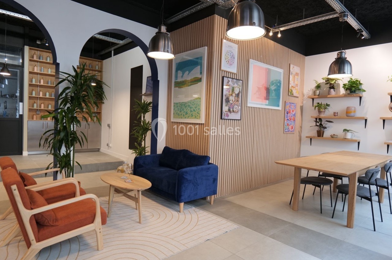 Espace intérieur moderne avec salon, table à manger, plantes, étagères décoratives et éclairage suspendu.