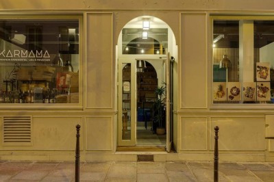 Façade d'un restaurant avec une vitrine éclairée, une porte centrale et des affiches de plats sur la droite.