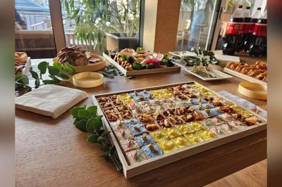 Façade d'un restaurant avec une vitrine éclairée, une porte centrale et des affiches de plats sur la droite.