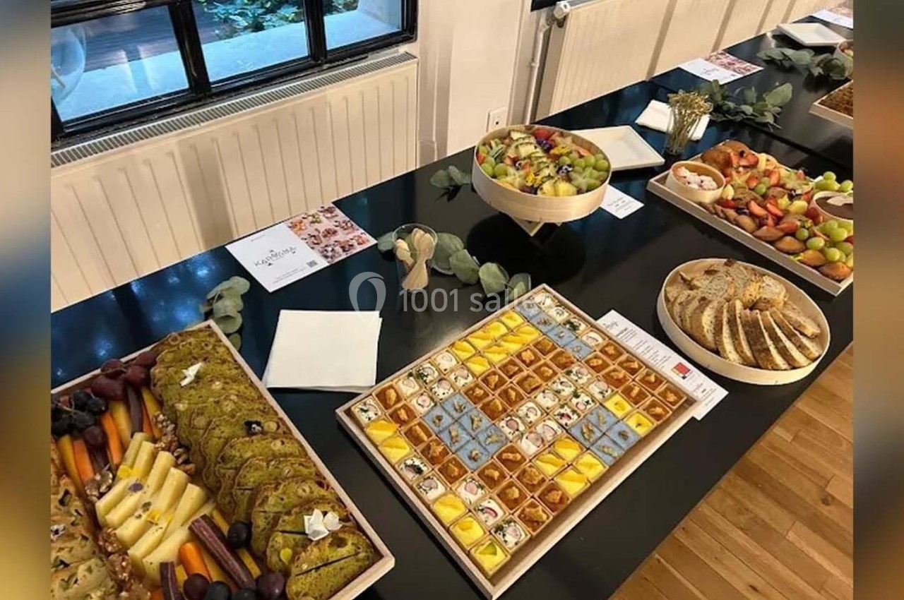 Table garnie de plats variés : fruits frais, pâtisseries, pains et amuse-bouches, disposés pour un buffet.