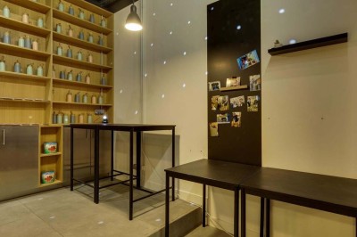 Façade d'un restaurant avec une vitrine éclairée, une porte centrale et des affiches de plats sur la droite.