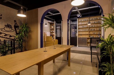 Façade d'un restaurant avec une vitrine éclairée, une porte centrale et des affiches de plats sur la droite.