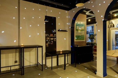 Façade d'un restaurant avec une vitrine éclairée, une porte centrale et des affiches de plats sur la droite.