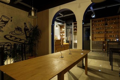 Façade d'un restaurant avec une vitrine éclairée, une porte centrale et des affiches de plats sur la droite.