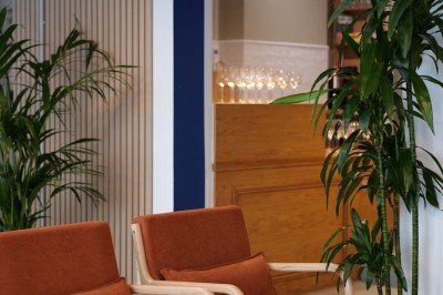 Façade d'un restaurant avec une vitrine éclairée, une porte centrale et des affiches de plats sur la droite.