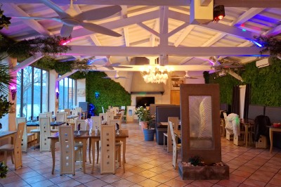 Vue d'un lac entouré de collines verdoyantes, avec quelques bateaux amarrés et un ciel partiellement nuageux.