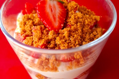 Vue d'un lac entouré de collines verdoyantes, avec quelques bateaux amarrés et un ciel partiellement nuageux.