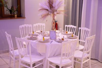 Centre de table avec structure dorée, bouquet de roses pastel et verres disposés sur une table dressée.