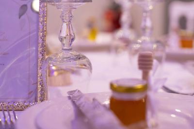 Centre de table avec structure dorée, bouquet de roses pastel et verres disposés sur une table dressée.