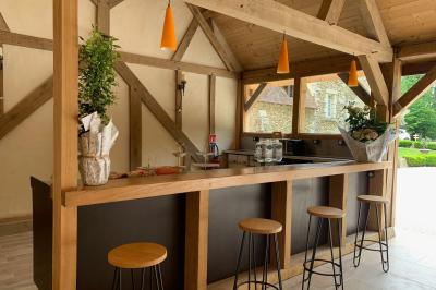 Champ ensoleillé bordé d'arbres, avec des rayons de soleil traversant le feuillage au premier plan.