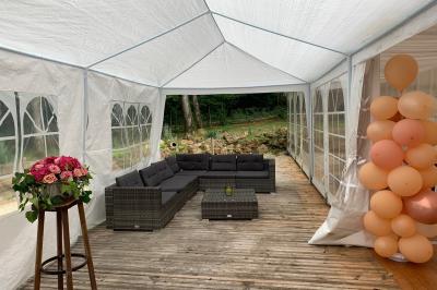 Champ ensoleillé bordé d'arbres, avec des rayons de soleil traversant le feuillage au premier plan.