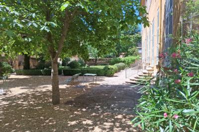 Hall d'entrée avec murs clairs, meubles en bois ancien et escalier montant à droite.