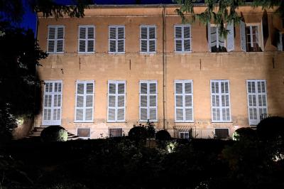 Hall d'entrée avec murs clairs, meubles en bois ancien et escalier montant à droite.