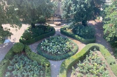 Hall d'entrée avec murs clairs, meubles en bois ancien et escalier montant à droite.