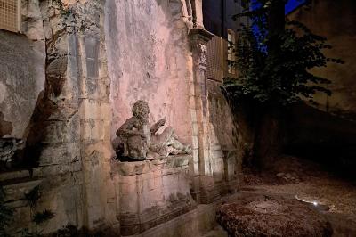 Hall d'entrée avec murs clairs, meubles en bois ancien et escalier montant à droite.