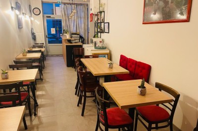 Salle lumineuse avec des tapis de yoga violets alignés sur un sol en bois, un piano et des décorations en arrière-plan.