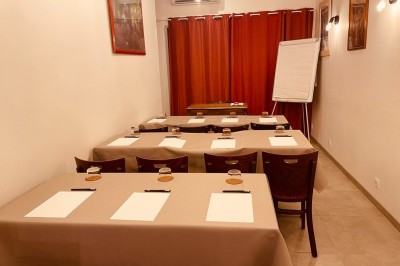 Salle lumineuse avec des tapis de yoga violets alignés sur un sol en bois, un piano et des décorations en arrière-plan.