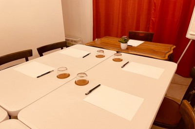 Salle lumineuse avec des tapis de yoga violets alignés sur un sol en bois, un piano et des décorations en arrière-plan.