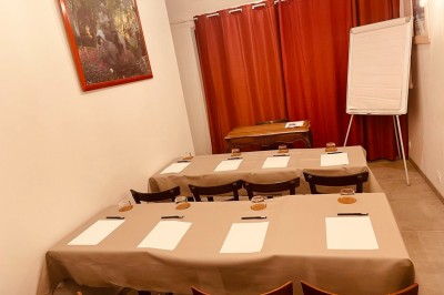 Salle lumineuse avec des tapis de yoga violets alignés sur un sol en bois, un piano et des décorations en arrière-plan.