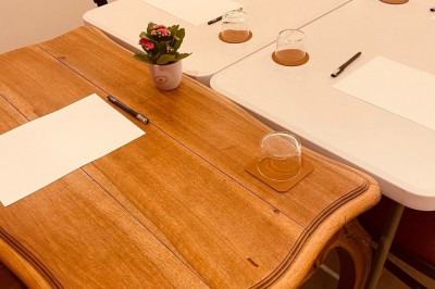 Salle lumineuse avec des tapis de yoga violets alignés sur un sol en bois, un piano et des décorations en arrière-plan.