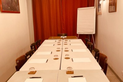 Salle lumineuse avec des tapis de yoga violets alignés sur un sol en bois, un piano et des décorations en arrière-plan.