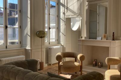 Salle de réunion lumineuse avec table en bois, quatre chaises, un tableau de présentation et une fenêtre donnant sur des…