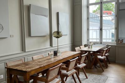 Salle de réunion lumineuse avec table en bois, quatre chaises, un tableau de présentation et une fenêtre donnant sur des…
