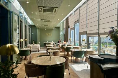 Salle de réunion lumineuse avec table en bois, quatre chaises, un tableau de présentation et une fenêtre donnant sur des…