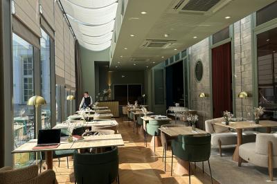 Salle de réunion lumineuse avec table en bois, quatre chaises, un tableau de présentation et une fenêtre donnant sur des…