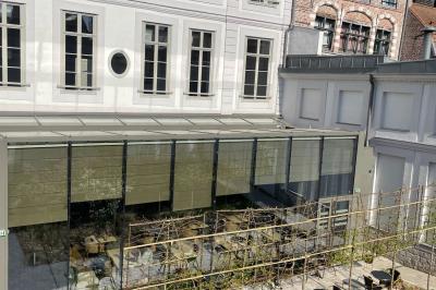 Salle de réunion lumineuse avec table en bois, quatre chaises, un tableau de présentation et une fenêtre donnant sur des…