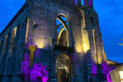 Salle équipée de plans de travail en inox, évier et carrelage gris, avec un panneau ’L'Eglise’ au mur.